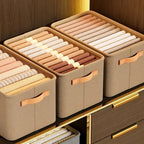 Cestos organizadores de tecido bege com roupas dobradas em armário moderno