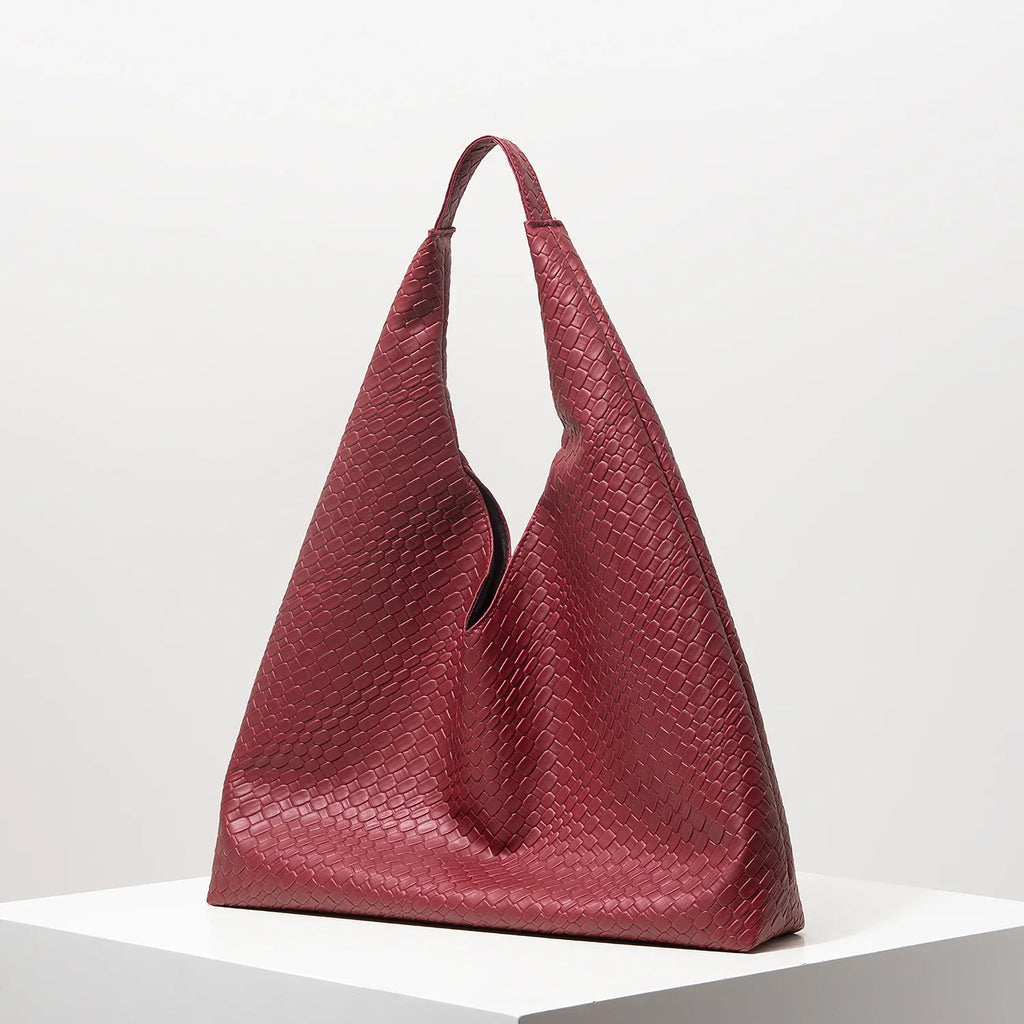 Bolsa feminina vermelha de couro texturizado, formato triangular, elegante em fundo branco.