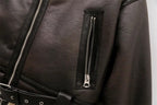 Detalhe de jaqueta de couro preta com zíper e cinto prateado