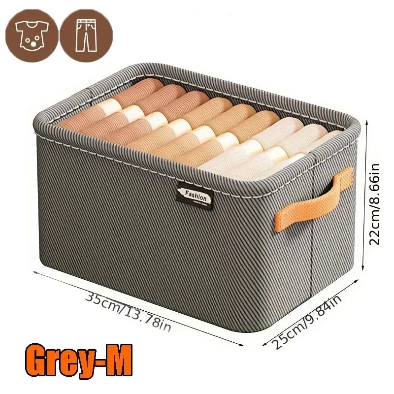 Cesto organizador cinza médio de tecido com alça, dobrado, ideal para roupas ou calças.